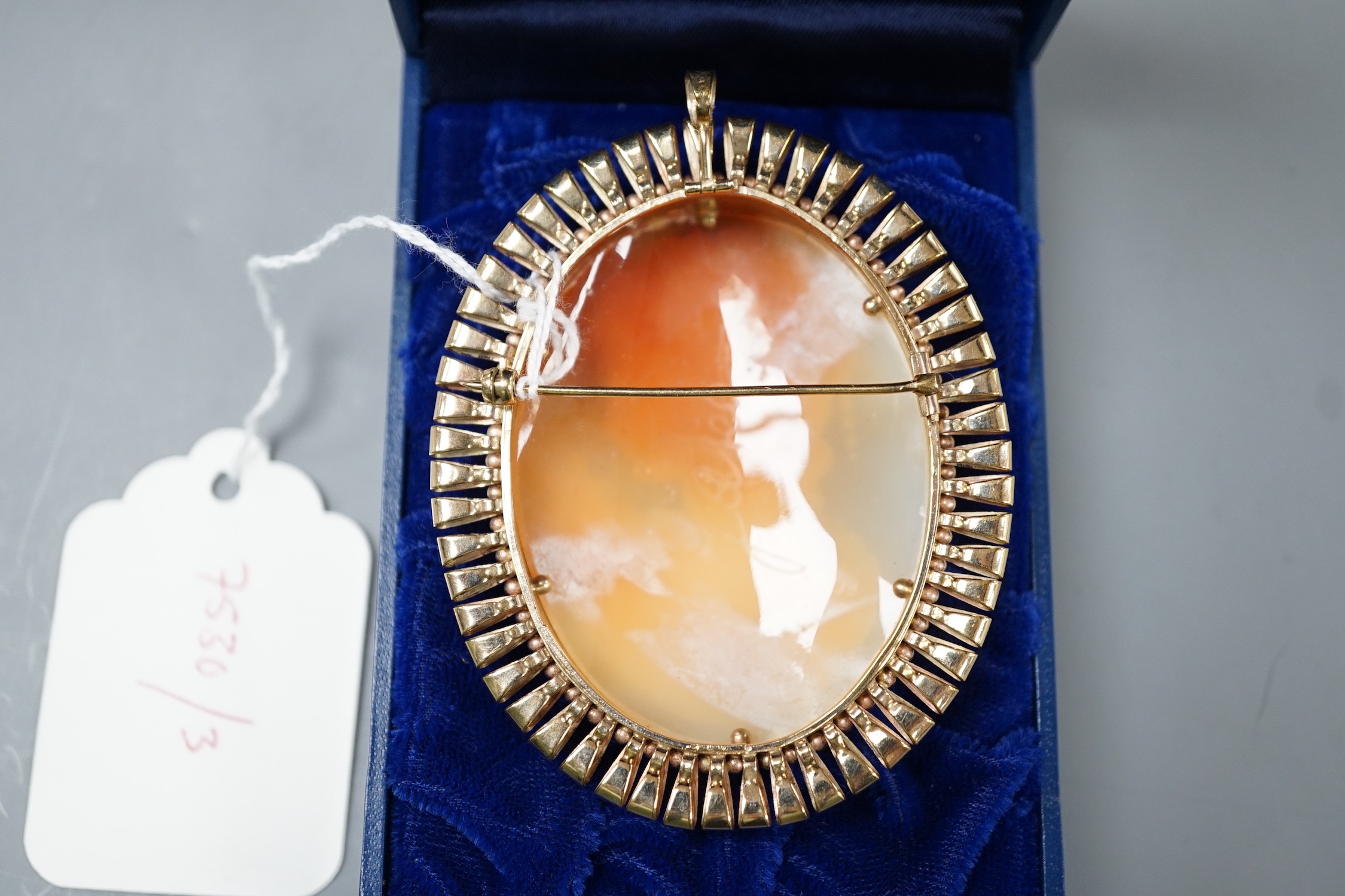 A modern 9ct gold mounted oval cameo shell pendant brooch, 74mm, gross weight 37.7 grams.